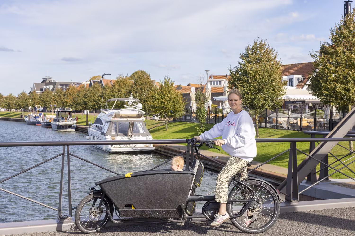 Vrouw op een bakfiets bij de haven van Harderwijk
