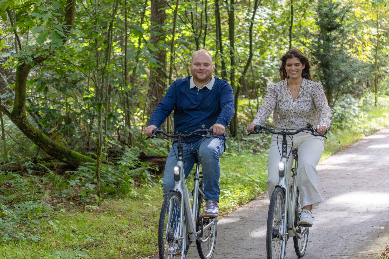 Man en vrouw fietsen door het bos
