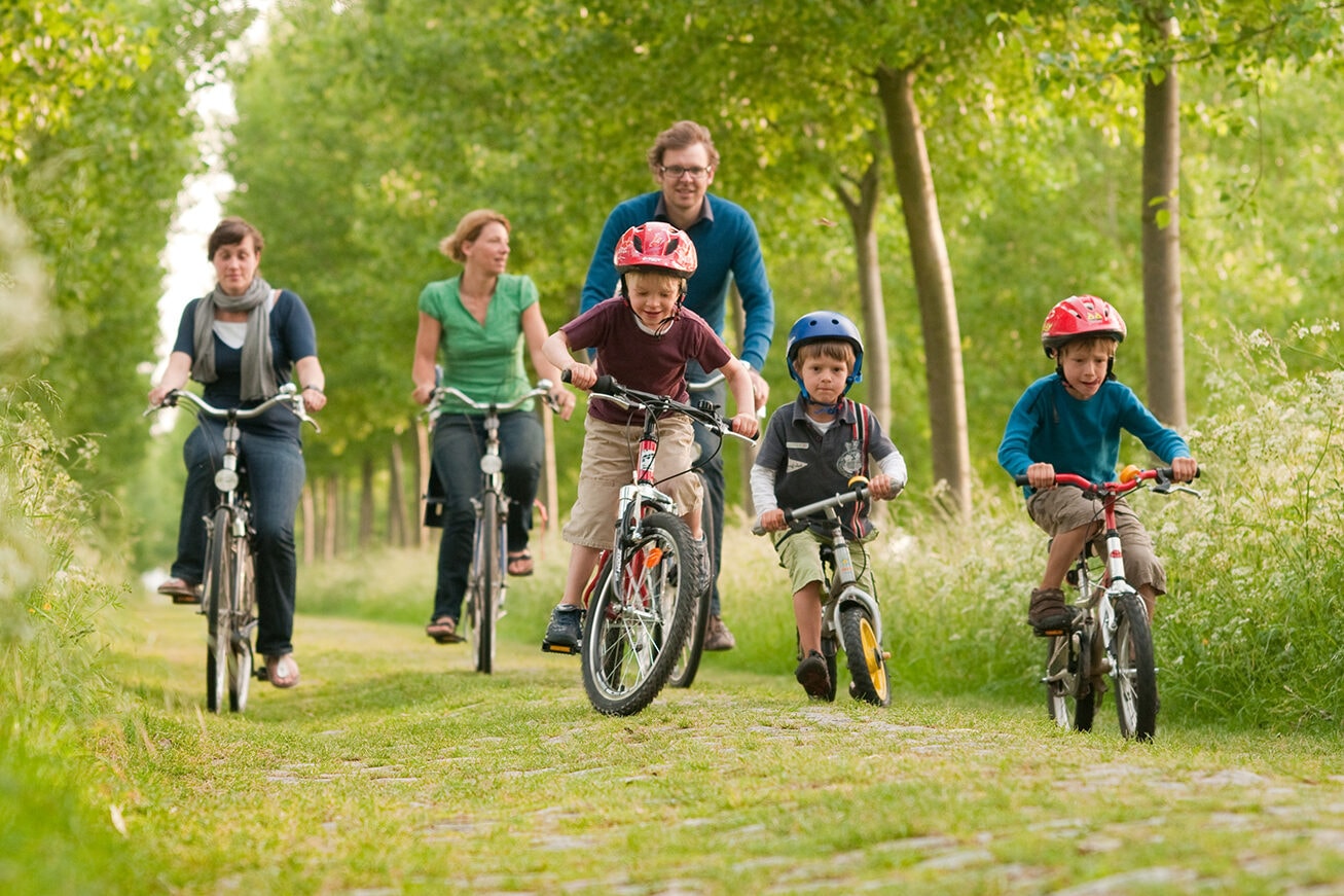 Gezin met kinderen op fietsen in het bos
