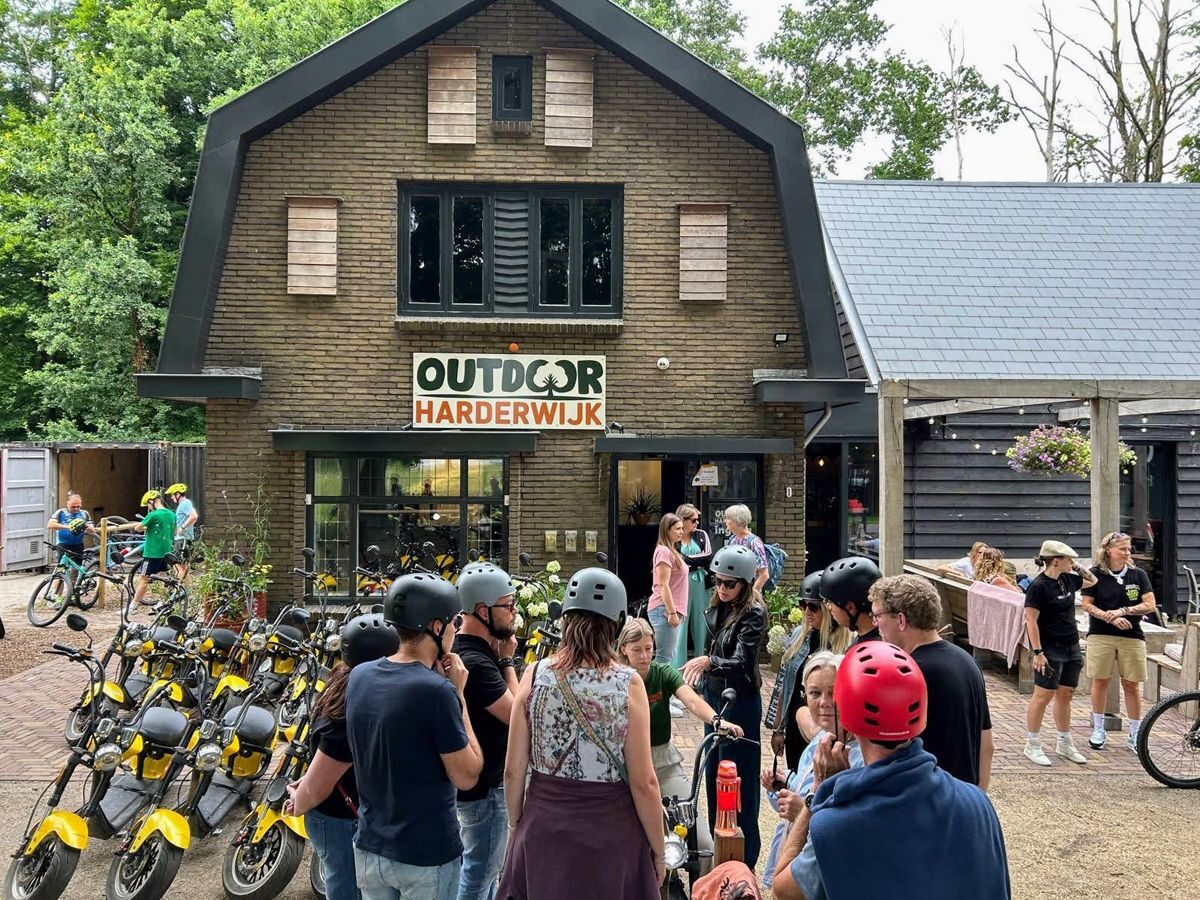 Groep gasten met e-choppers voor het pand van Outdoor Harderwijk
