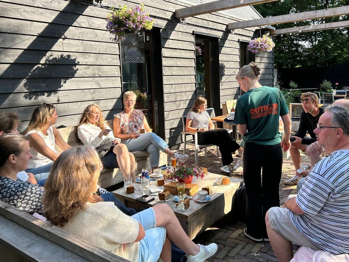 Gasten met koffie op het terras van Outdoor Harderwijk