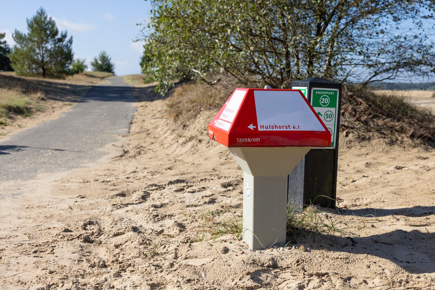 Radfahrer am Knotenpunktpfosten in den Sanddünen