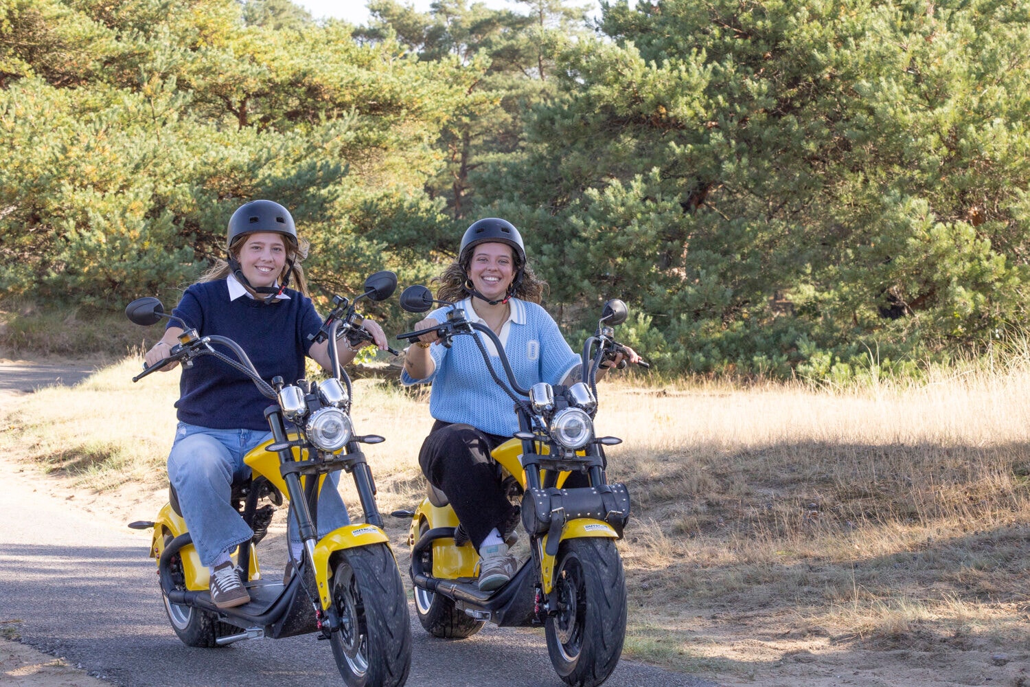 Zwei Frauen fahren auf gelben E-Choppern durch die Natur bei Harderwijk