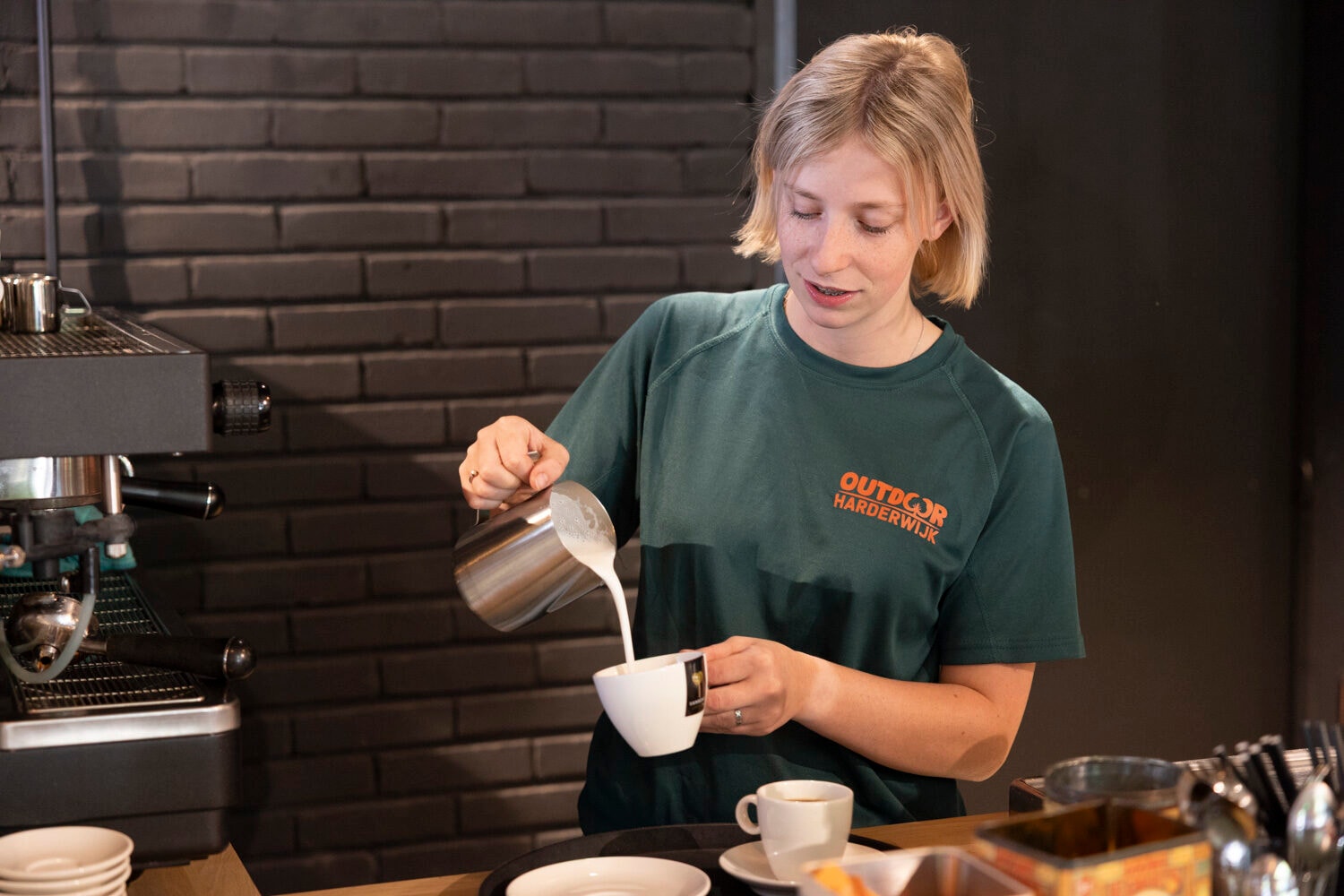 Mitarbeiterin schenkt Kaffee ein