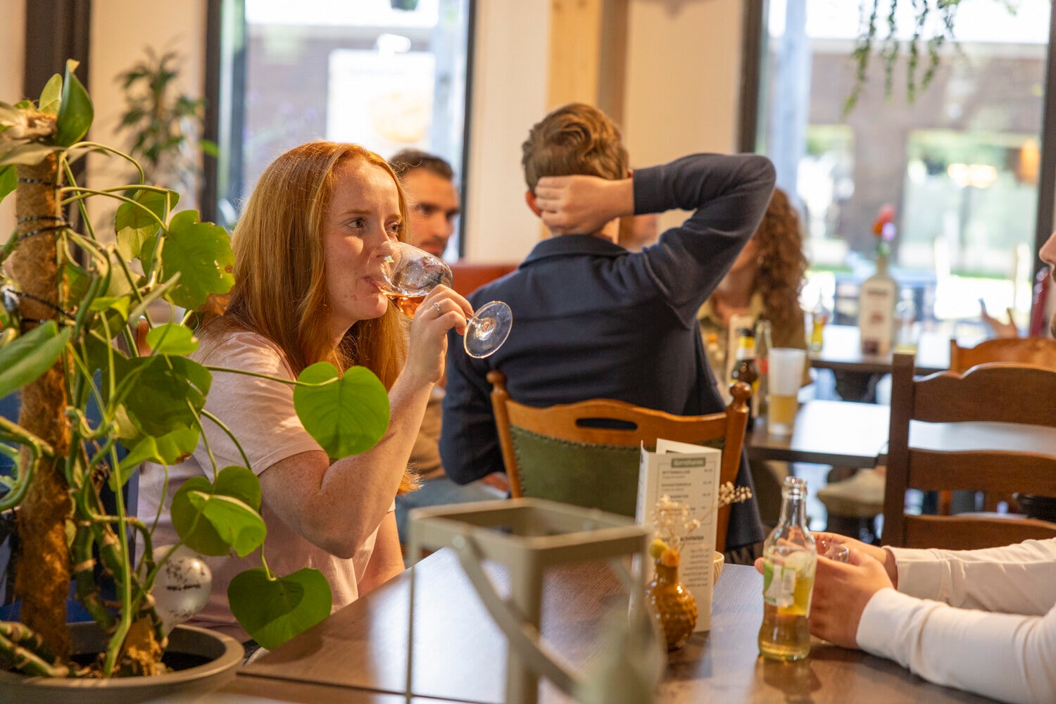 Vrouw drinkt een glas wijn aan tafel