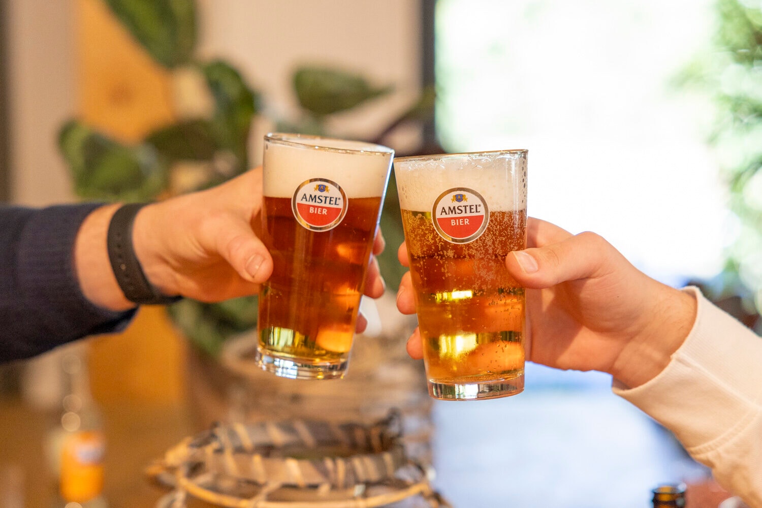 Twee handen proosten met glazen bier bij Outdoor Harderwijk
