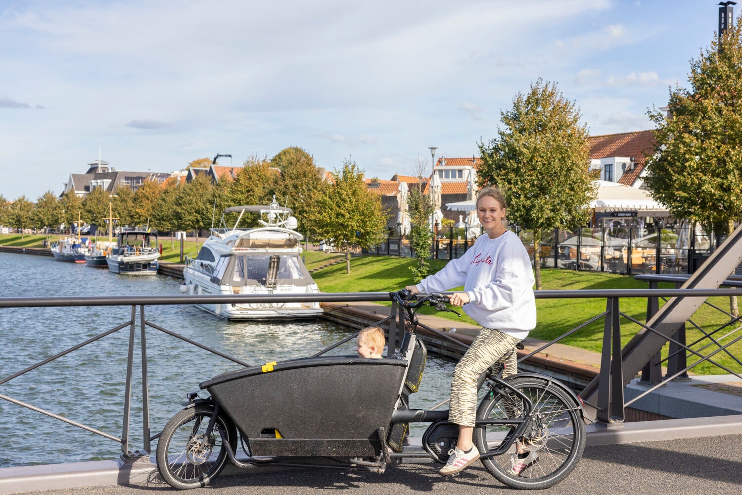 Vrouw op een elektrische bakfiets bij de haven van Harderwijk