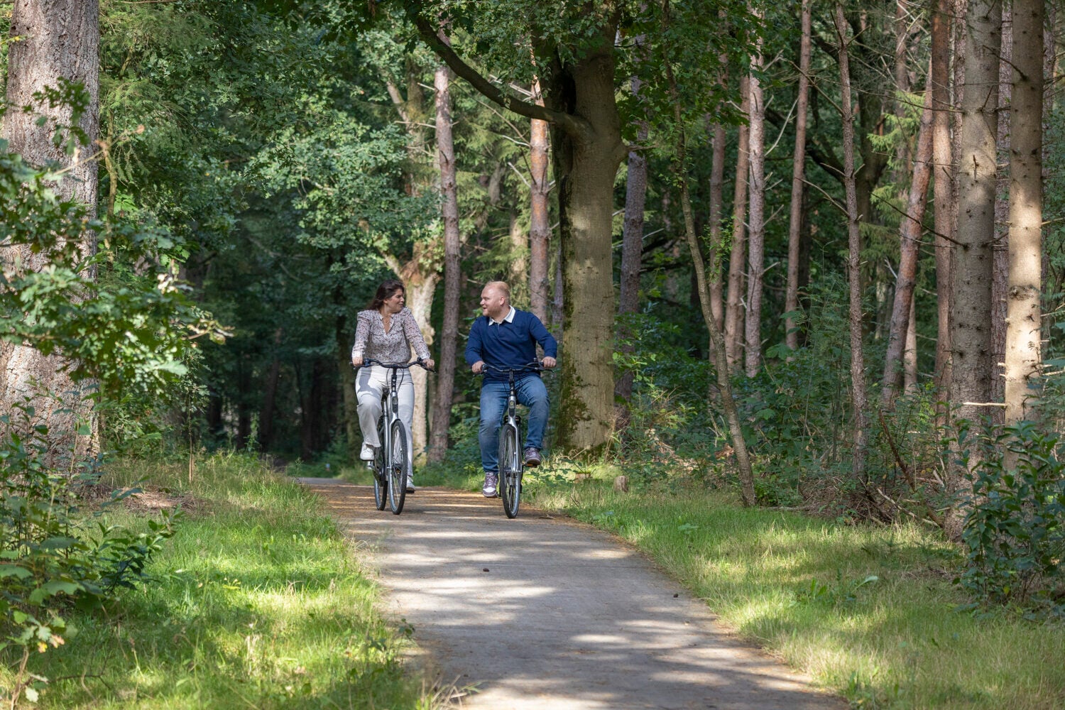 Vrouw en man fietsen door het bos bij Harderwijk