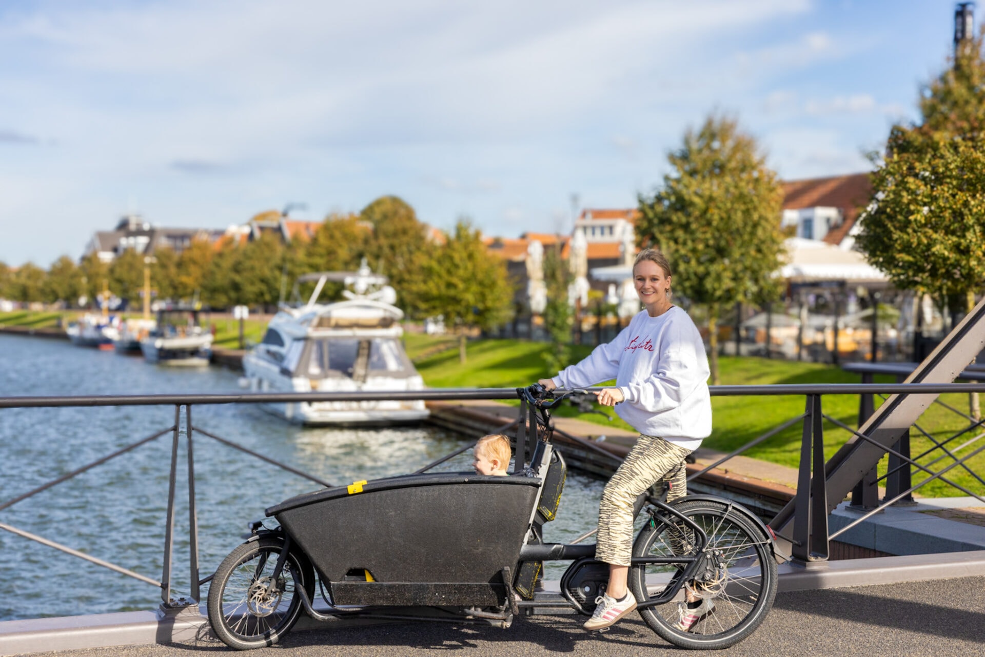Vrouw op een e-bakfiets bij de haven van Harderwijk