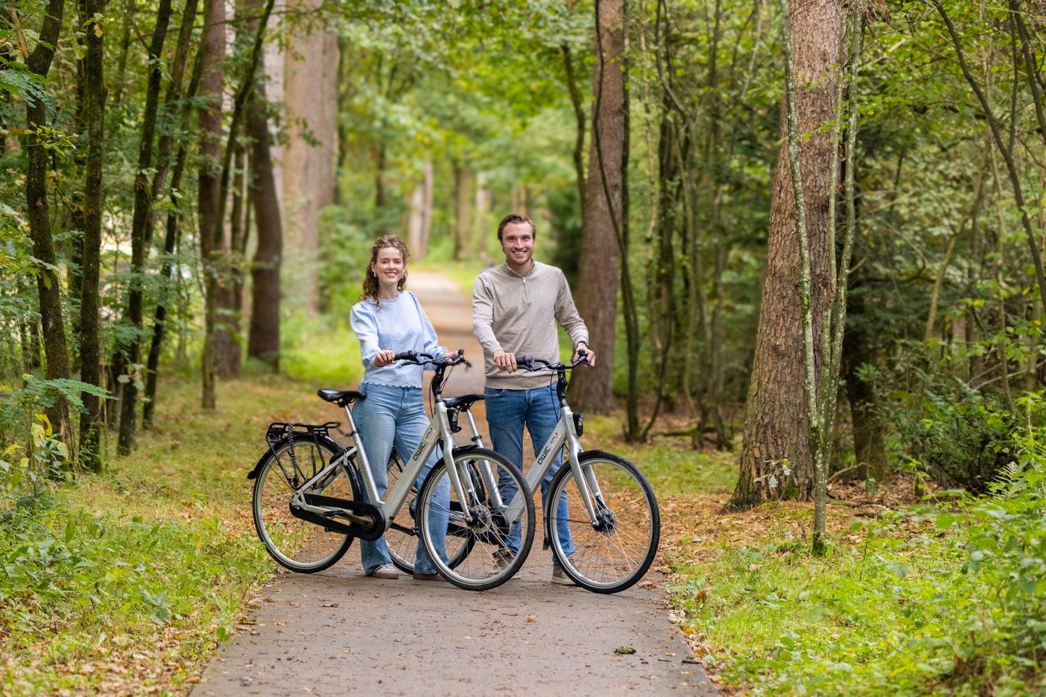 Man en vrouw met stadsfietsen op een bospad bij Harderwijk