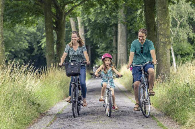 Man en vrouw met dochter op een gehuurde kinderfiets