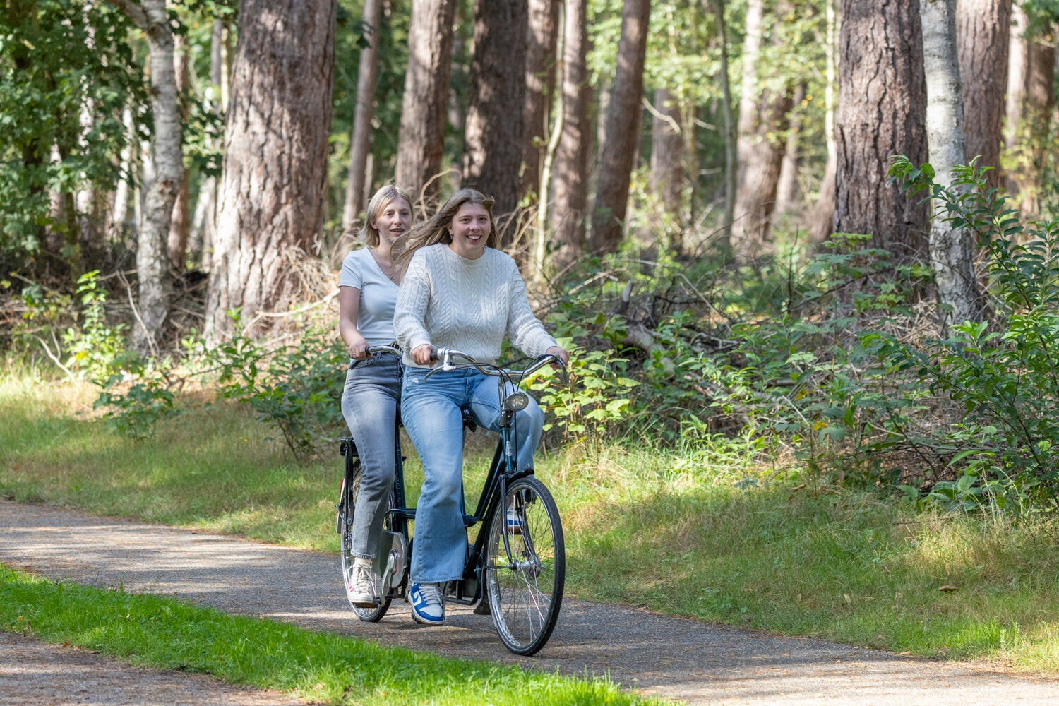 Tandem op een bospad in de zon