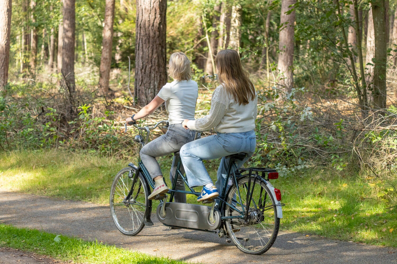 Paar fährt auf einem Tandem durch den Wald