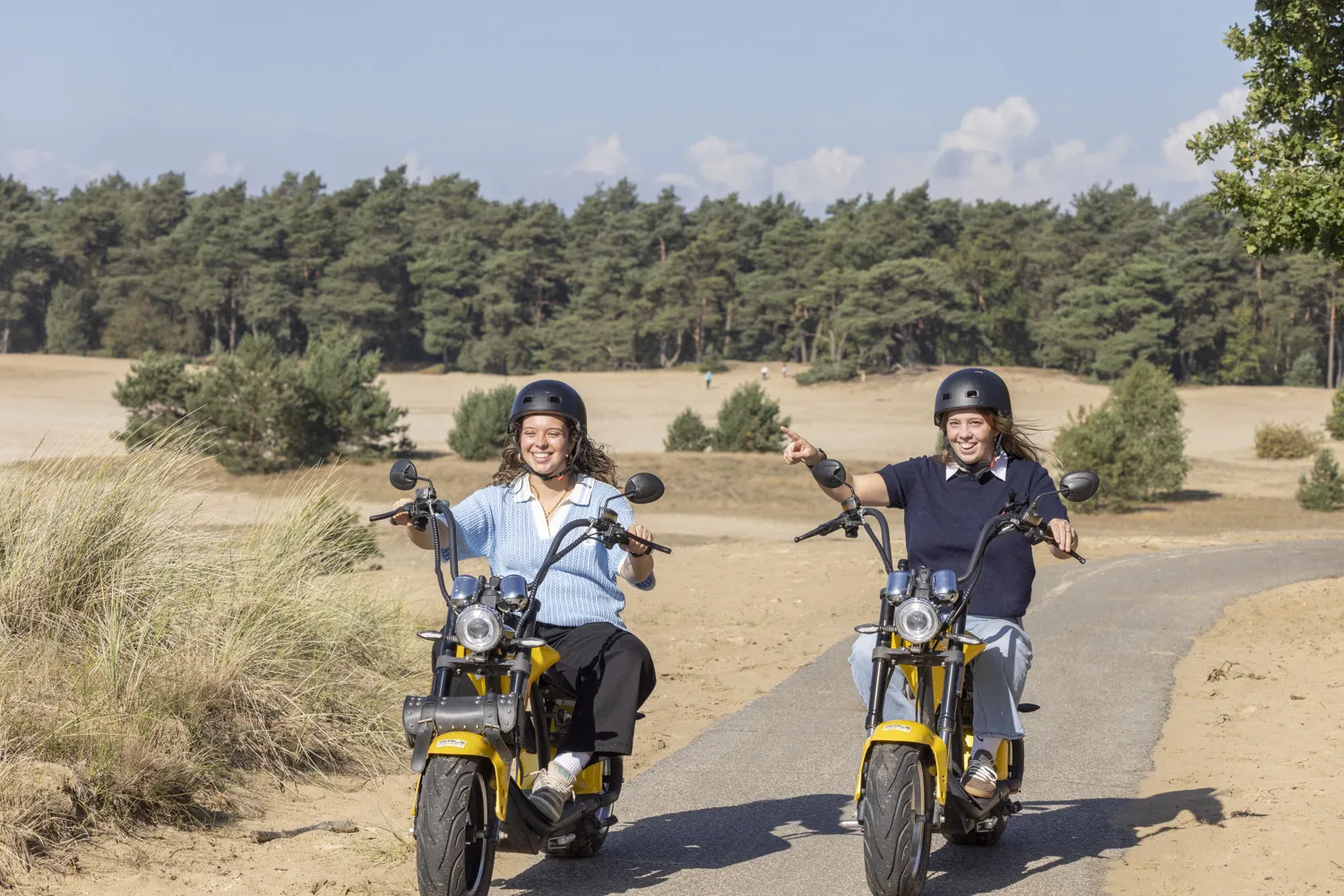 Twee vrouwen maken uitje op e-choppers over fietspad bij de Ermelosche Heide nabij Harderwijk