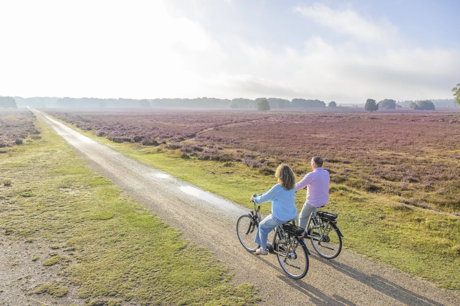 Stel fietst op e-bike over de Ermelosche Heide tijdens De Outdoor Route van Harderwijk