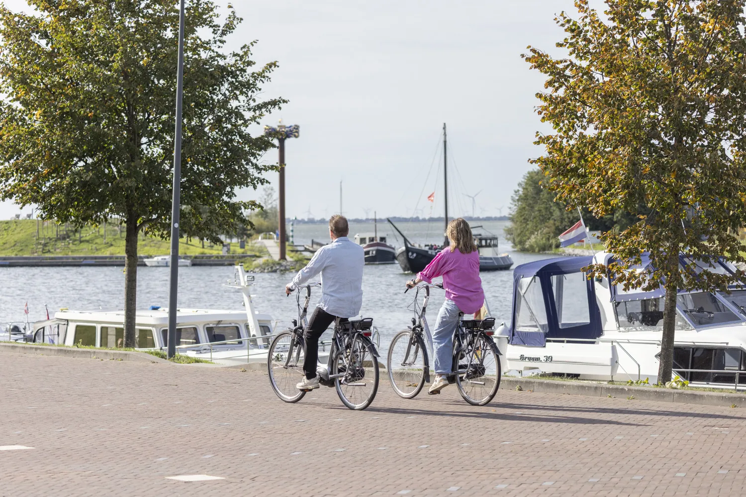 Fietsers langs de haven van Harderwijk met uitzicht op het Veluwemeer