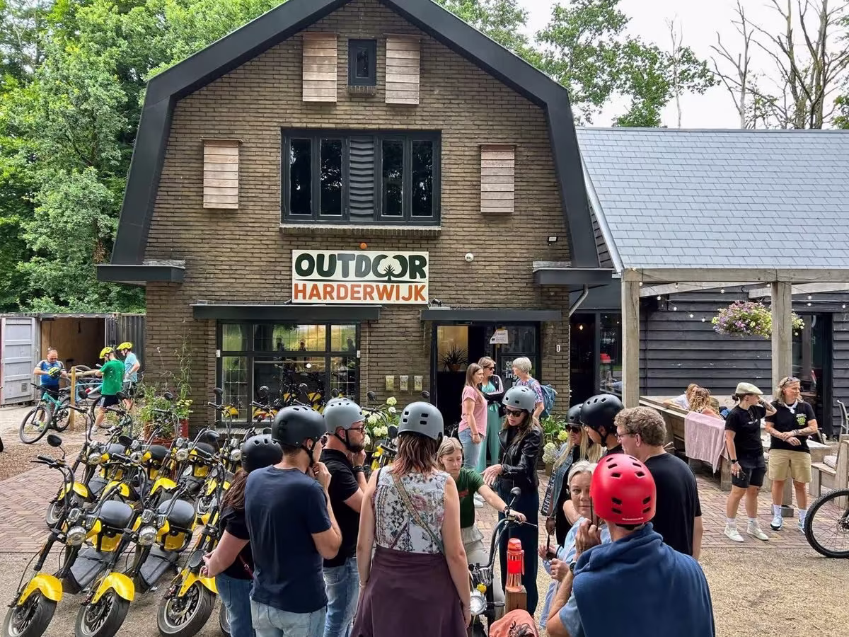 groep gasten met E-choppers voor pand Outdoor Harderwijk