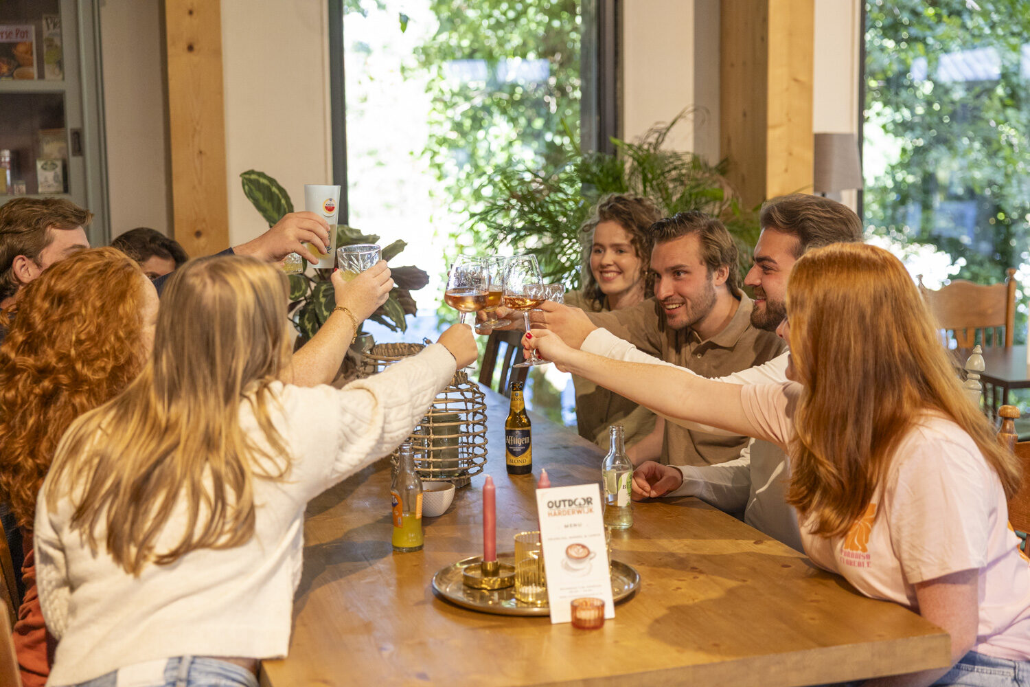 groep vrienden is aan het borrelen en heft het glas in Outdoor Harderwijk restaurant