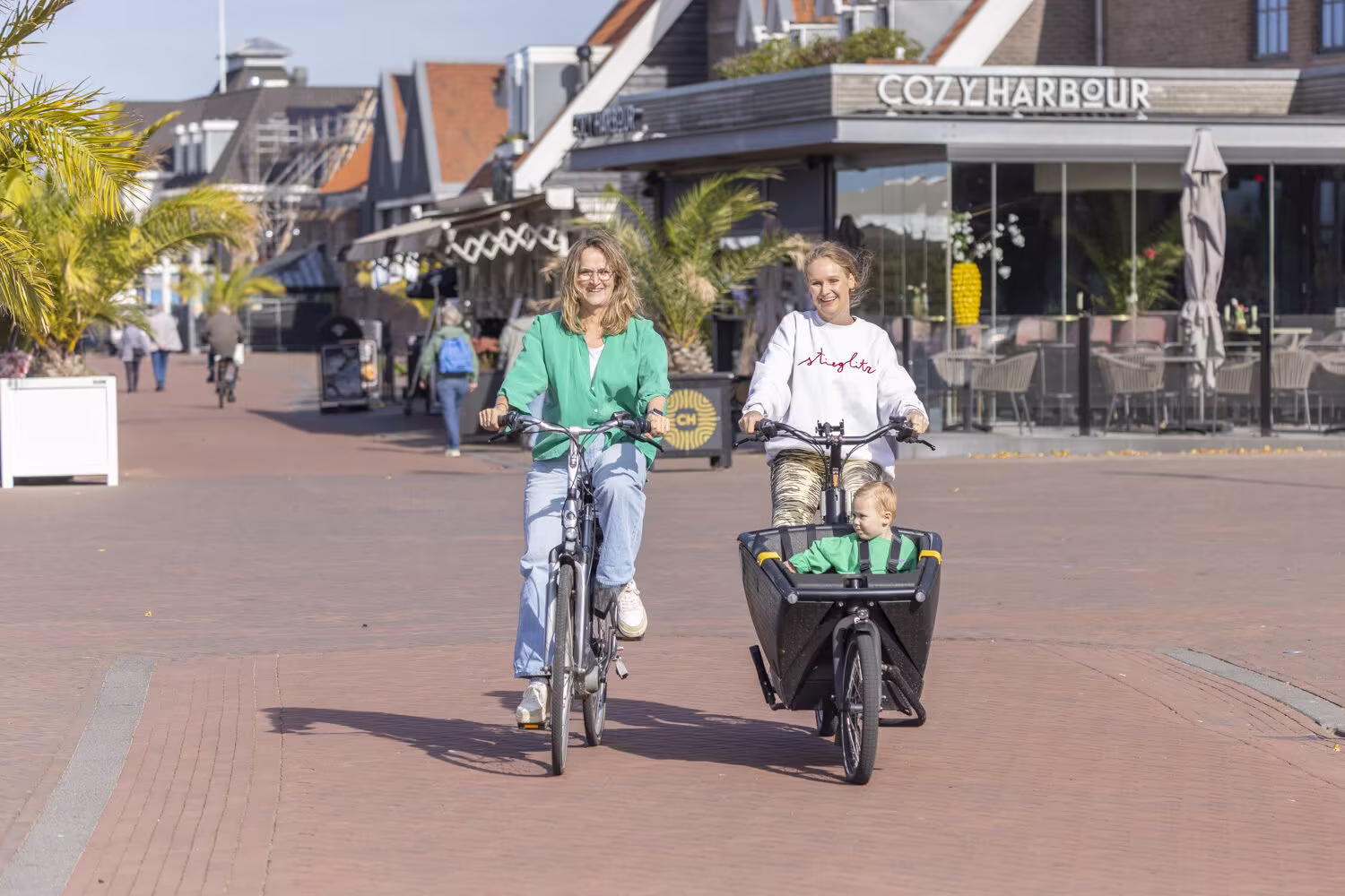 moeder met kind op bakfiets en vriendin op elektrische fiets in harderwijk