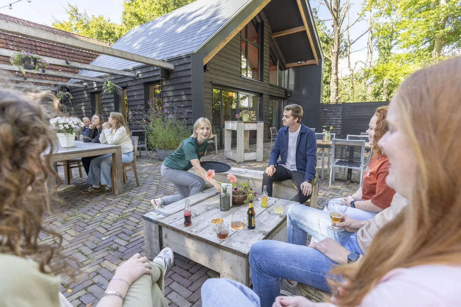 Groep vrienden borrelend op het terras van Outdoor Harderwijk na het fietsen van een fietsroute