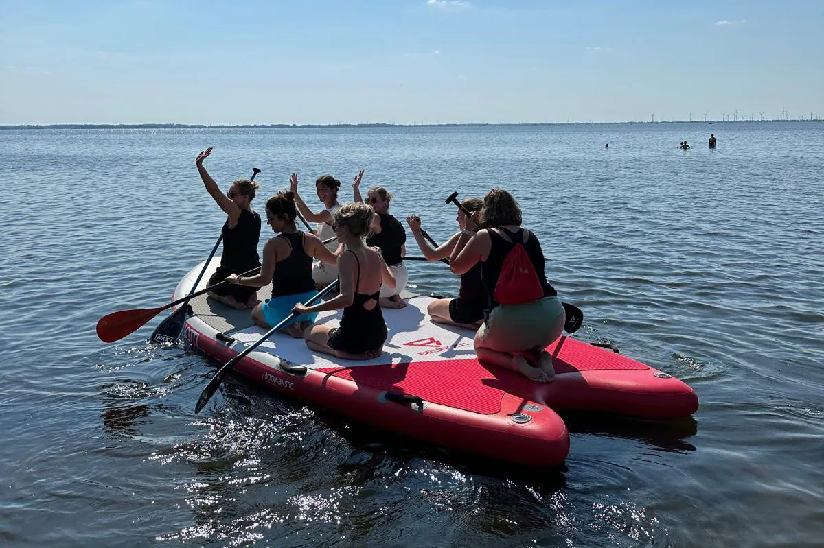 Groep mensen op een mega SUP op het Wolderwijd bij Harderwijk tijdens een outdoor activiteit