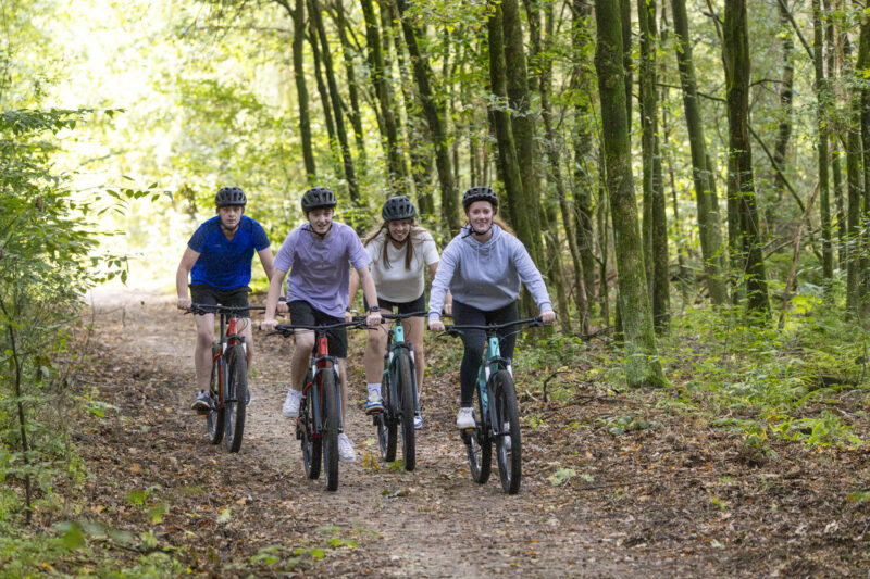 Vrienden die samen mountainbiken door de Veluwse bossen tijdens een vriendenuitje in Harderwijk