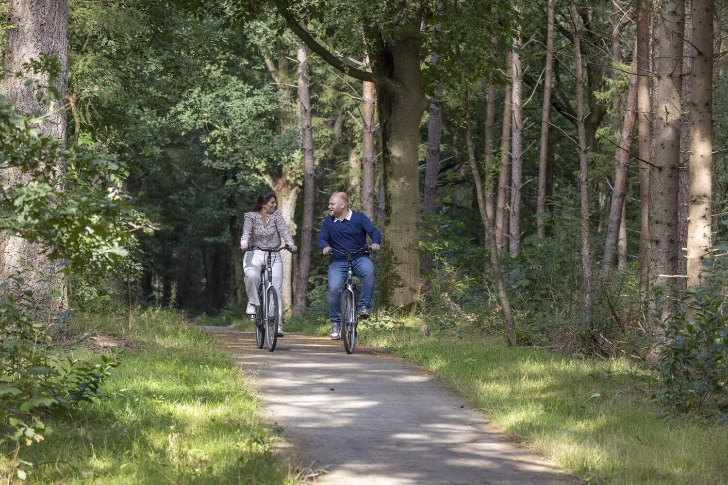 vrouw en man fietsen in bos Harderwijk op gehuurde stadsfietsen van Outdoor Harderwijk